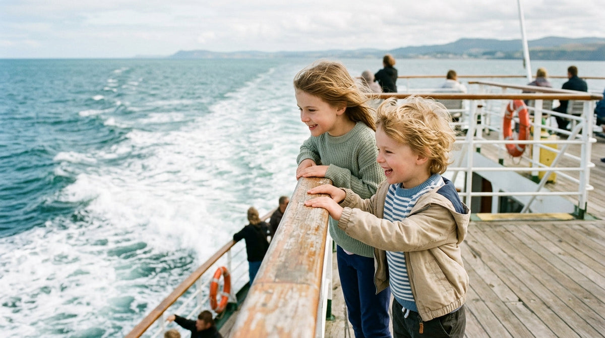 Children delighting in the wake and sea view from the deck of a family holiday ferry